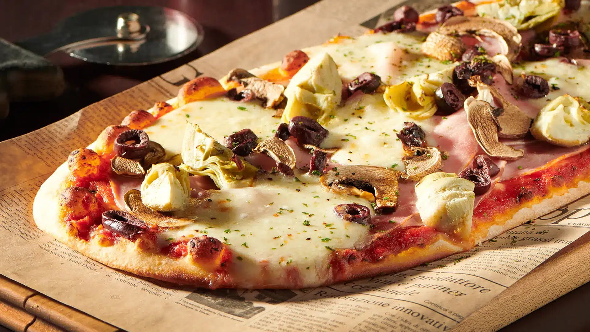 Pizza Capricciosa garnie de champignons, artichauts, jambon et fromage